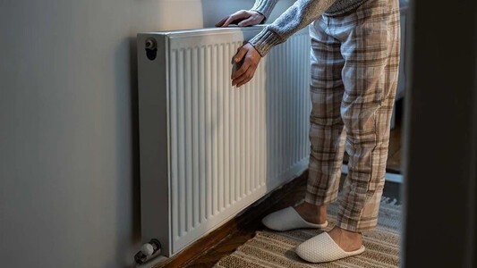 Person heating hands against a radiator