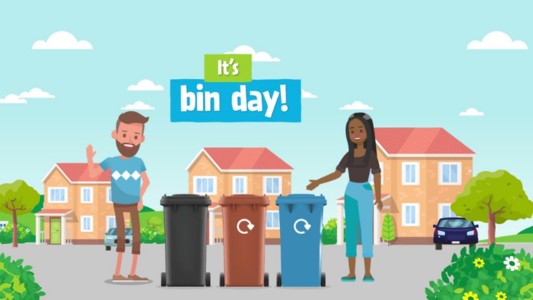 Two people taking out the paper recycling bin