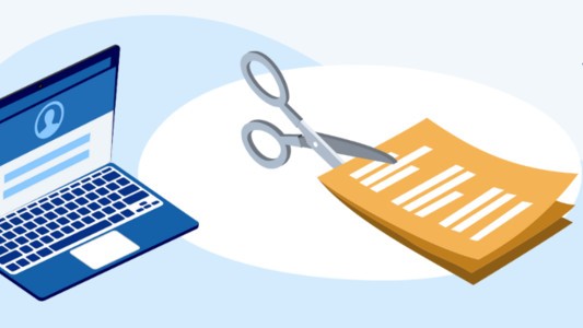 Blue laptop next to an electricity bill being cut by scissors 