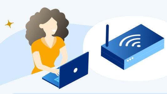 Image of a person using a laptop alongside a wifi modem