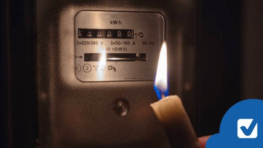 Lit candle in front of electricity meter